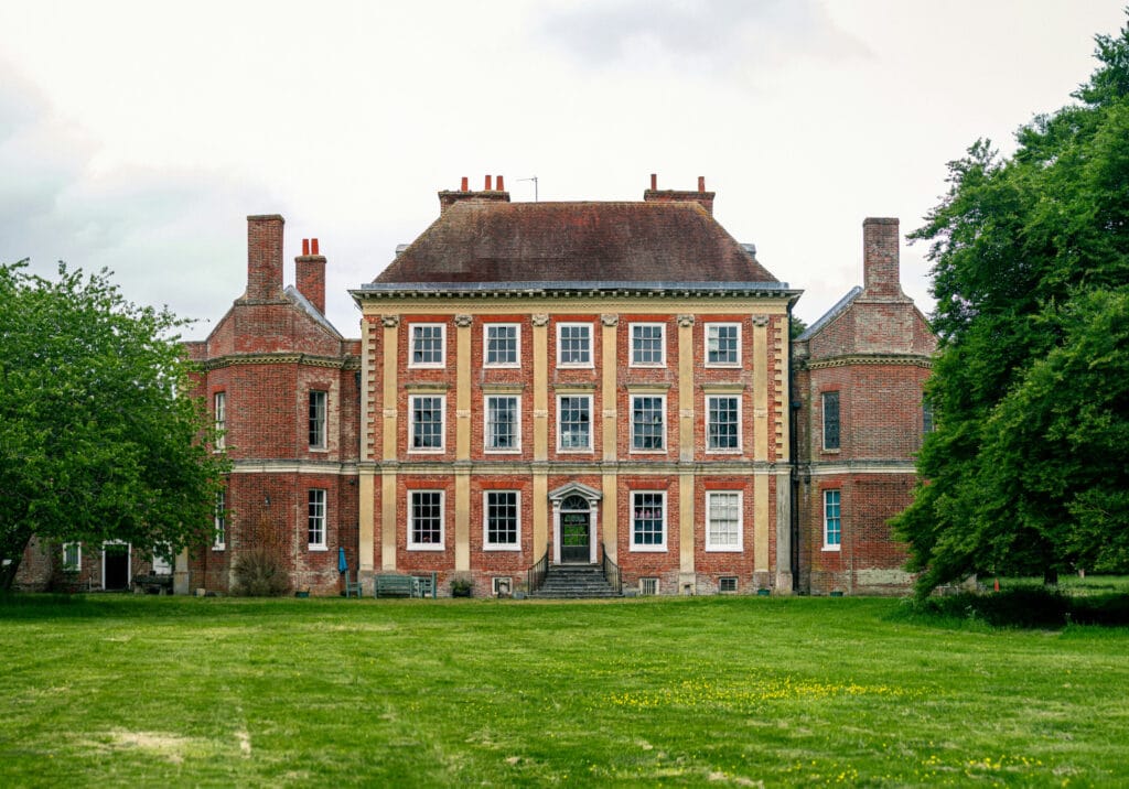 Old mansion building at the end of grass lawn.