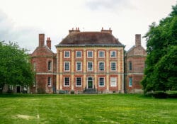 Old mansion building at the end of grass lawn.