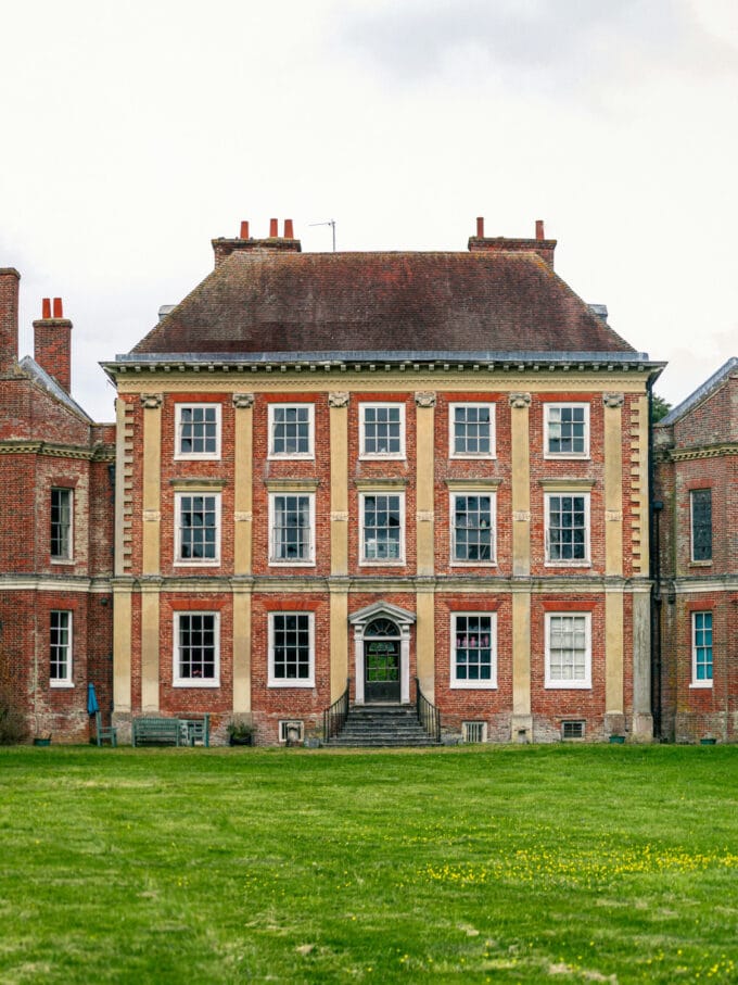 Old mansion building at the end of grass lawn.
